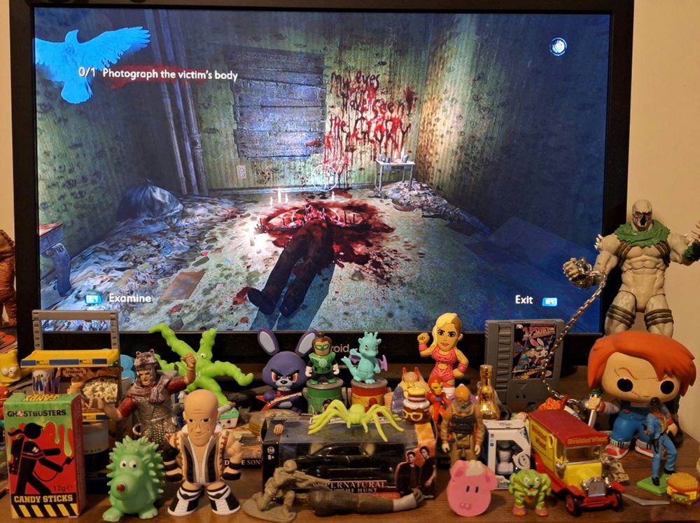 The Malcolm Van Horn crime scene from the Preston Hotel level, his body lays splayes on the ground with his chest cavity exposed & part of his face removes. A ring of blood surrounds him & is illuminated by several candles. Scrawled in red is the message 'MY EYES HAVE SEEN THE GLORY'