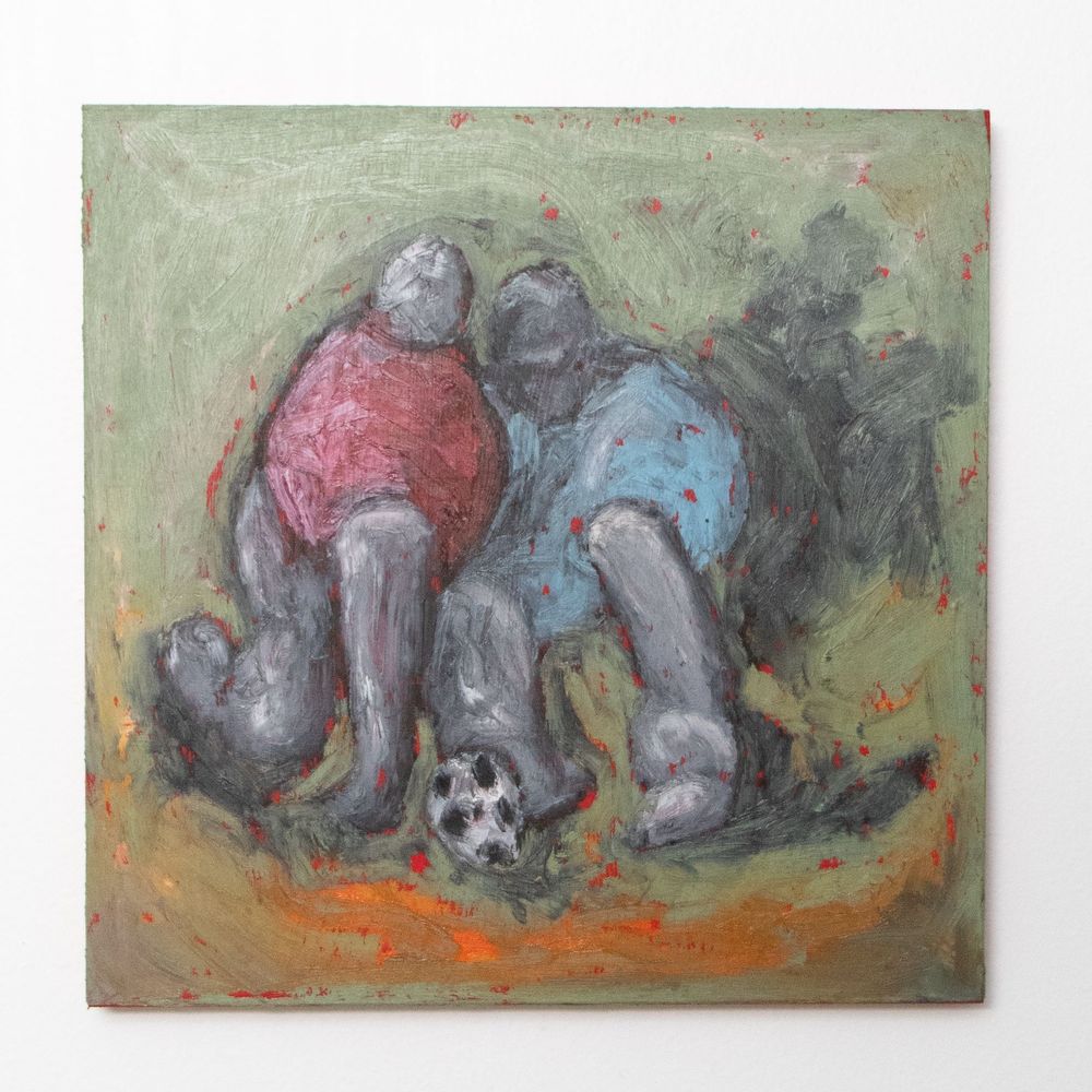 An oil pigment stick painting on a square wood panel, loosely painted scene of two figures fighting for control of a soccer ball. The figure on the left is wearing a red shirt/torso, has a grey head with no facial features or hair, and grey legs, and is pushing up against the figure on the right, slightly in front of them. The figure on the right has a blue shirt/torso, a grey head with no facial features, and grey legs. The soccer ball sits in between the two, on the ground. The ground is a mix of orange, brown, and grey shadows. The green makes up most of the background, with flecks of red peeking through, showing the red acrylic underpainting. 