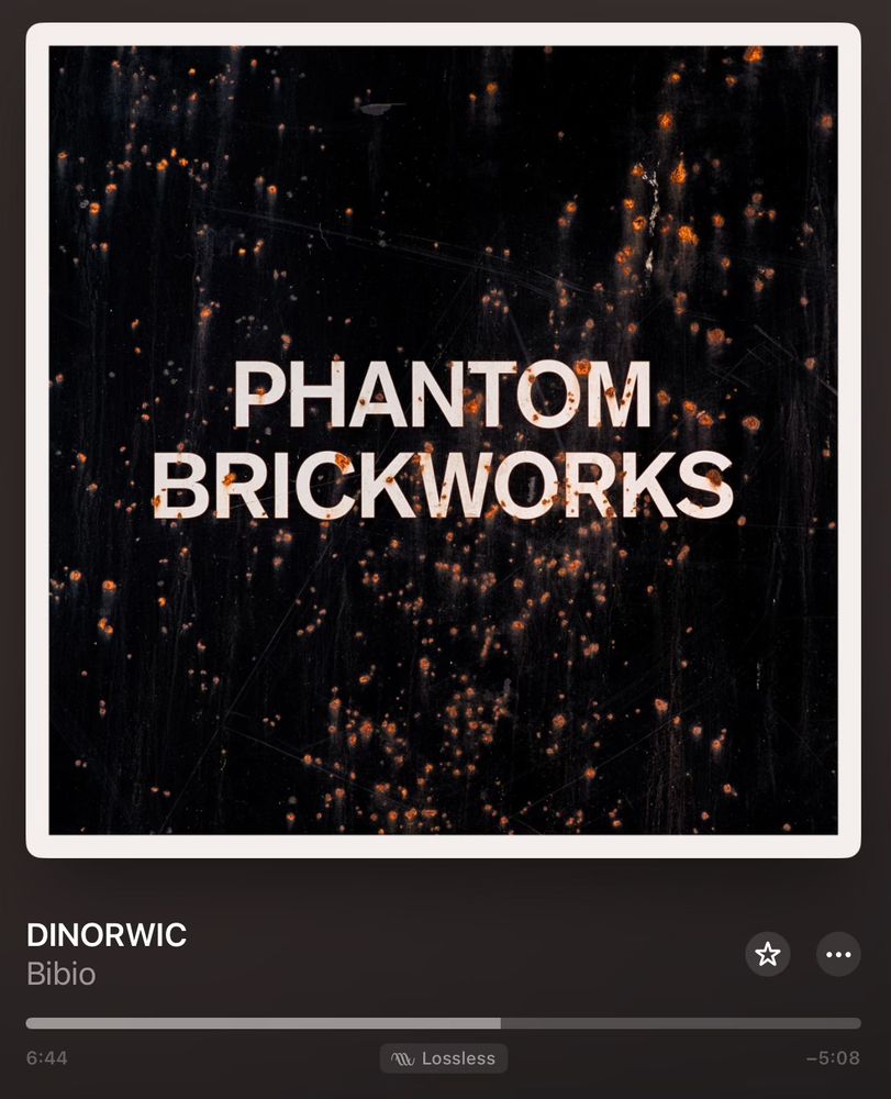A screenshot of the Apple Music UI showing the user listening to the first track, DINORWIC off the new Phantom Brickworks II album by the artist Bibio. The play bar is a little past the halfway point, and an indicator shows that the album is playing in lossless format