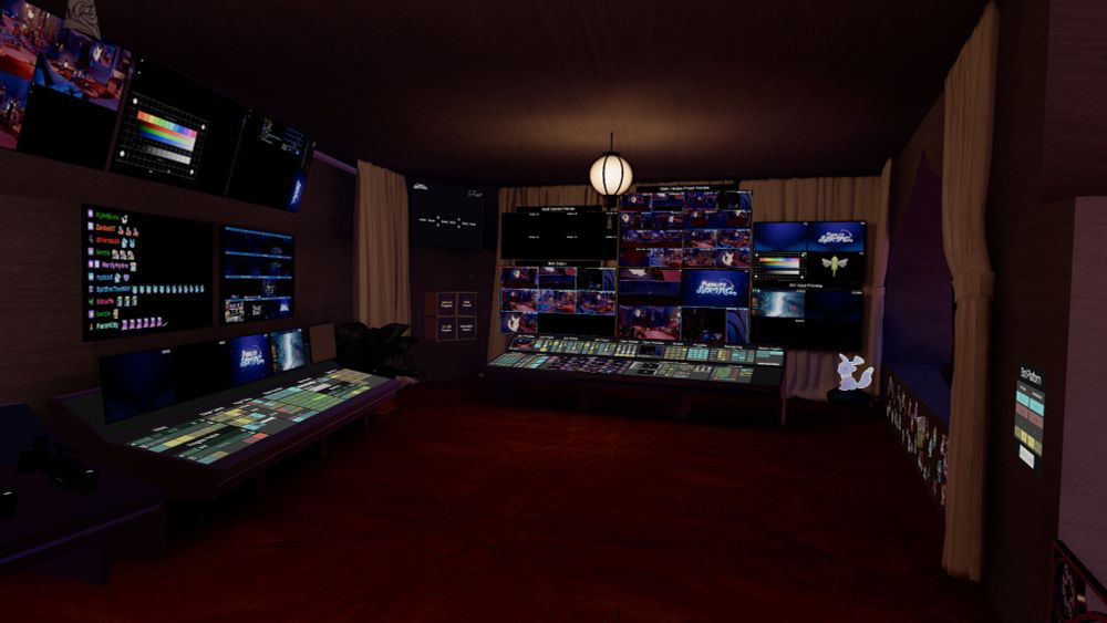 A view of the control booth for the events host world in VRChat. The walls have many displays on the walls showing camera feeds, with control consoles in front of them. A dream creature sits to one side.