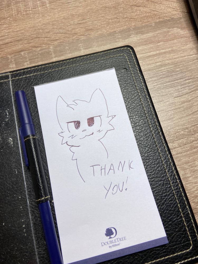 The “boy kisser” cat with a thank you message left at the hotel, drawn by @snoodlewolfieb