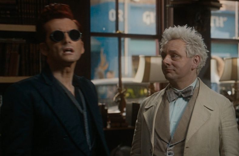 Crowley and Aziraphale in the bookshop. Aziraphale on the right is gazing adoringly at Crowley 