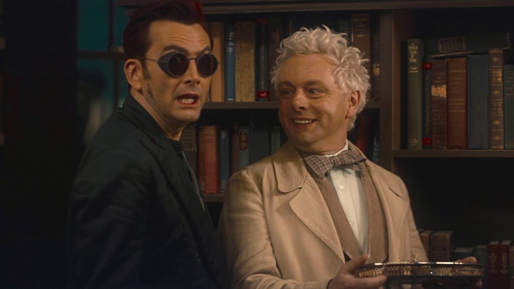 At the Ball, Aziraphale holds a platter and smiles at Crowley who stands beside him