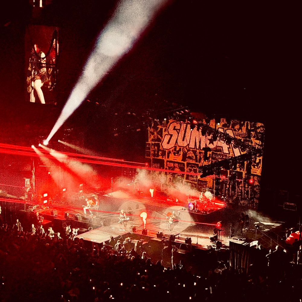 Nose bleed view of the Sum41 main stage, the stage lit by fire spires, smoke and red lasers 