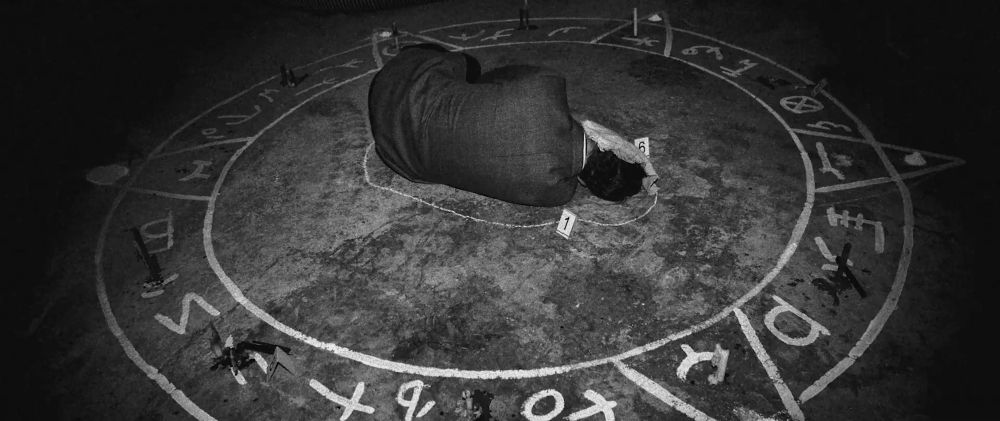 A man’s bodies lies on the floor with strange ritual markings around him in the film 🎥