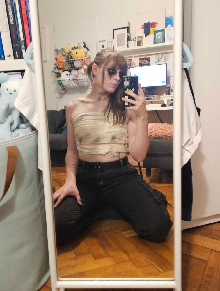 another mirror selfie of me with a Vi cosplay, kneeling on the floor