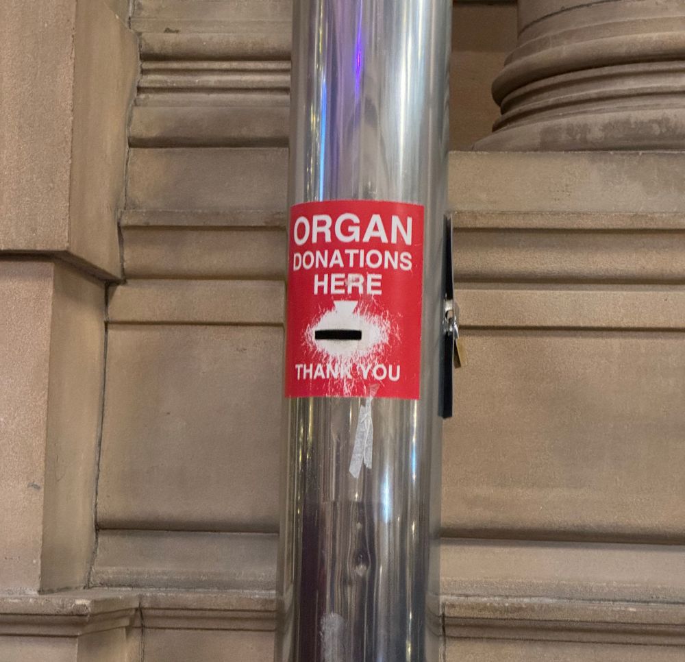 A pole with a 
ORGAN DONATIONS
HERE
THAN YOU
sticker with a slot for money 