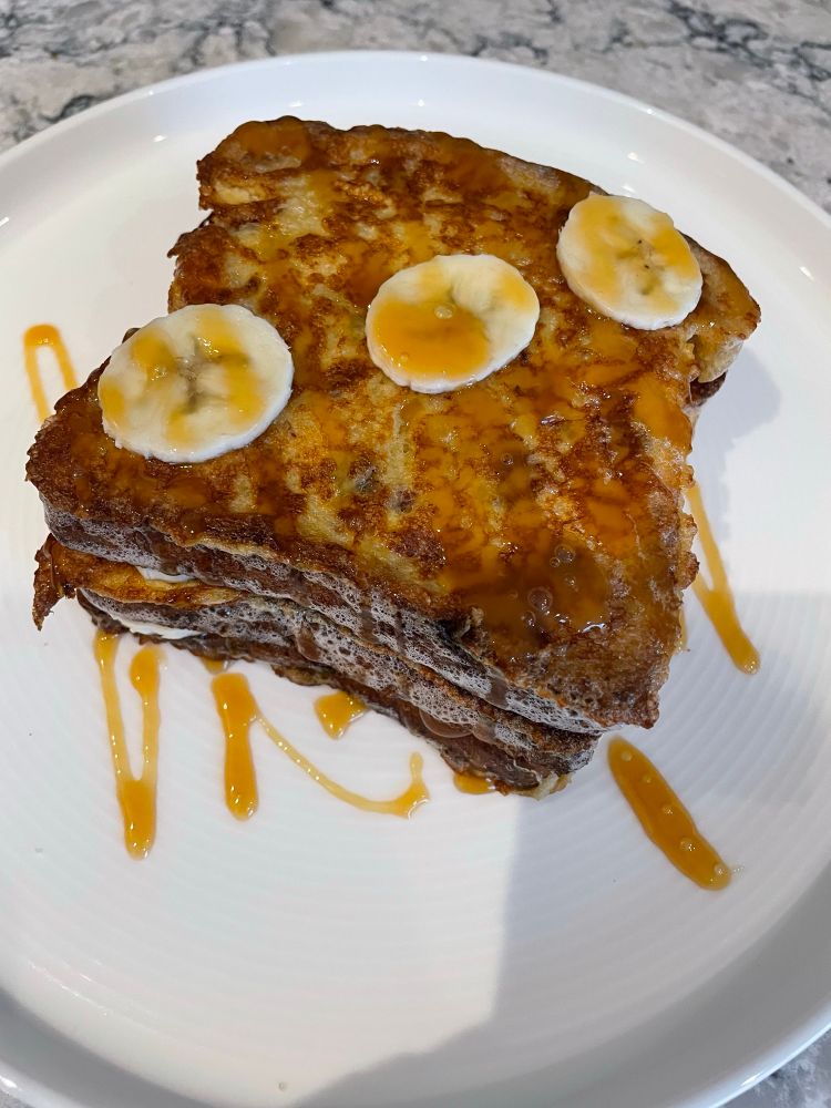 Banana-Caramel French Toast on a white dinner plate.