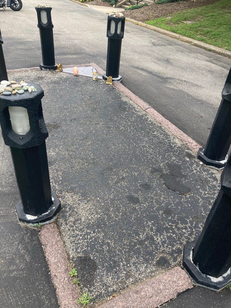 A rectangular space in a parking lot outlined by pink granite and short pillars. It outlines the spot where Jeffrey Miller was shot by National Guardsmen on the Kent State University campus on May 4, 1970. 