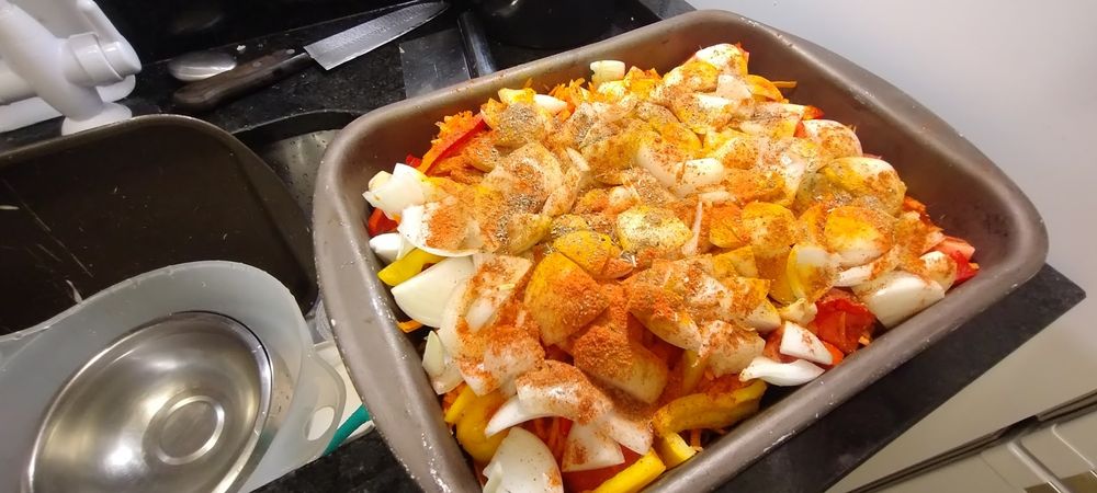 assadeira com legumes picados e condimentos secos espalhados sobre eles