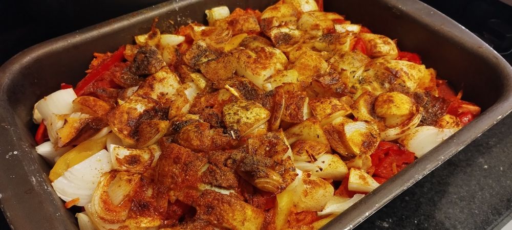 assadeira com diversos legumes temperadors e levemente assados e queimados por cima