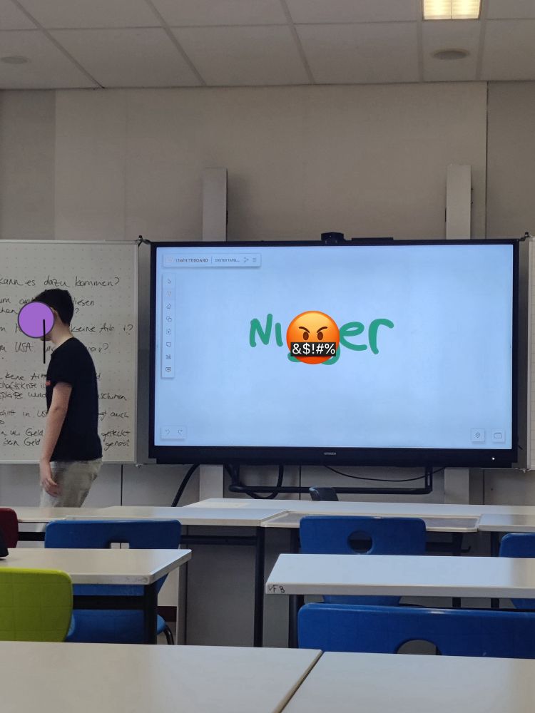 Classroom digital whiteboard with the N-word written in large green letters. 