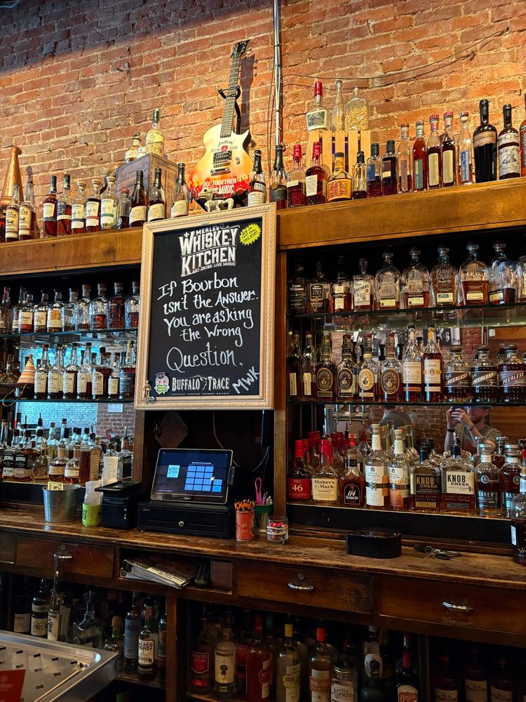 Photo of a bourbon bar with a chalk board that says “If bourbon isn’t the answer you are asking the wrong question.”