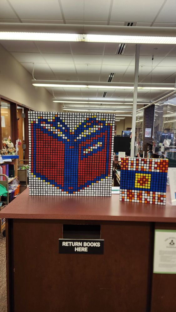 Library book made from 144 Rubik's Cubes on a circulation desk in a middle school library. 