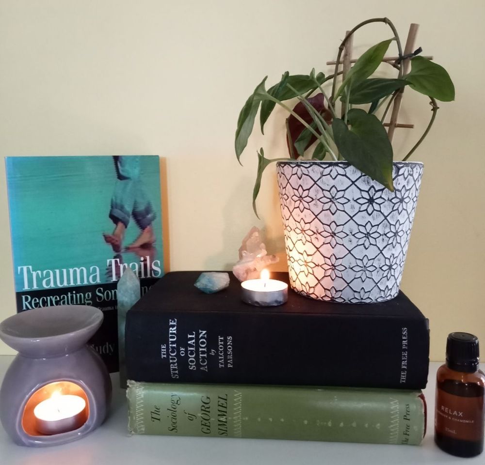 3 second hand books displayed with indoor plant, crystals and a candle.