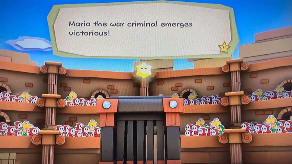 An announcer at the Golden Coliseum says: “Mario the war criminal emerges victorious!”