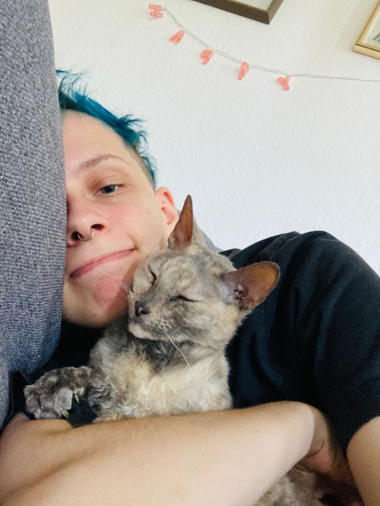 selfie of me and bertha the cat cuddling (she climbed in my arms!! 🥺)
