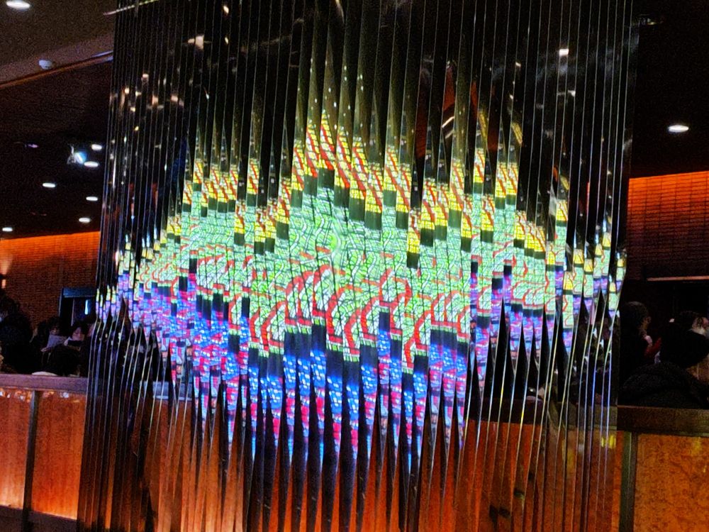 ステンドグラスが映り込んで美しく輝く、天井から下がるブラインド状のミラー