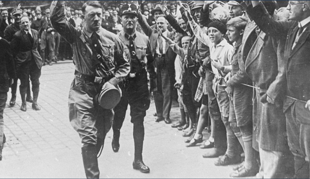 Picture of Hitler walking with crowds giving him a Nazi salute. Source: Holocaust Encyclopedia