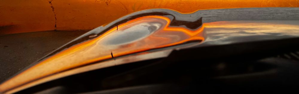 Sun-heart reflection on black car, raw