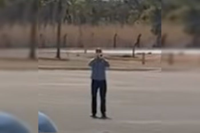 uma imagem desfocada mostrando, na distância, um homem soprando um trompete. 