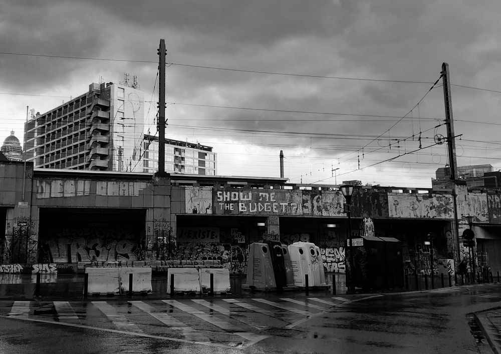 B/W inner city scape after rain. Dark rain clouds still looming overhead. Tower blocks in the background. 
