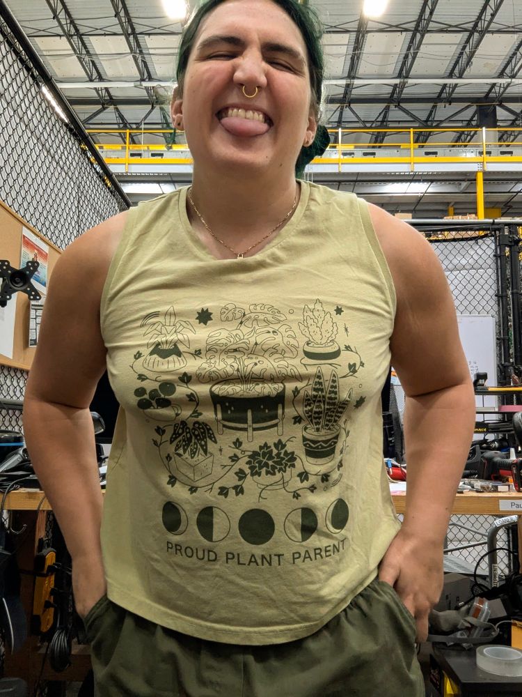 Radiance sticking her tongue out at the camera. Pup looks jacked and it's tank top is straining against breast and muscle. 
