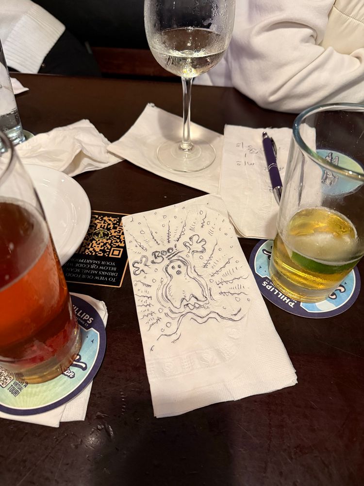 Pub table, full of drinks and napkin doodles. 