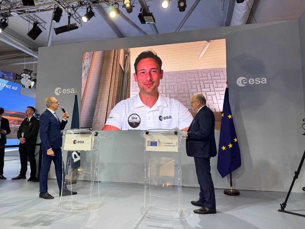 Astronaut Sławosz Uznański-Wiśniewski appears on screen at ESA's booth at the Paris Air Show.