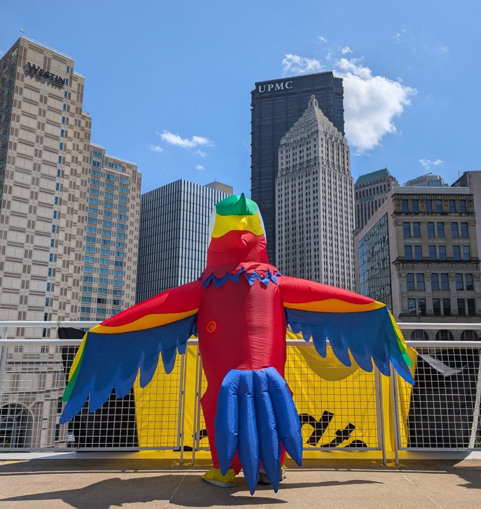 A picture of an inflatable costume looking toward the skyscrapers seen from the rooftop of the David Lawrence Convention Center, in Pittsburgh, Pennsylvania.
Taken during #Anthrocon 2025.
