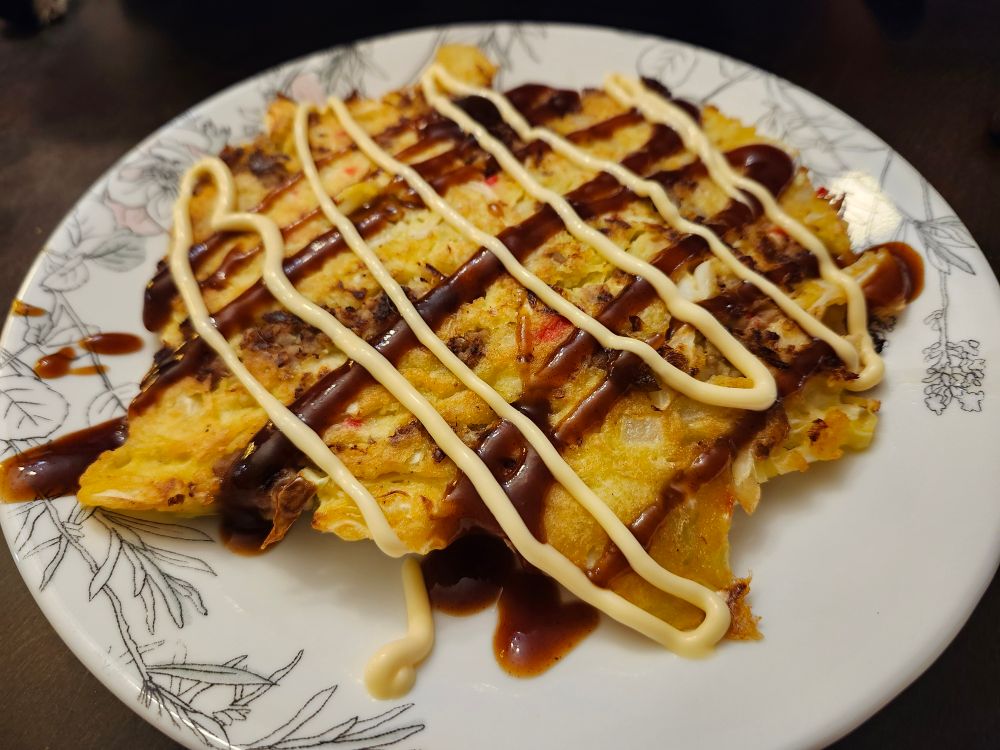 Japanese cabbage pancake decorated with brown sauce and mayonnaise