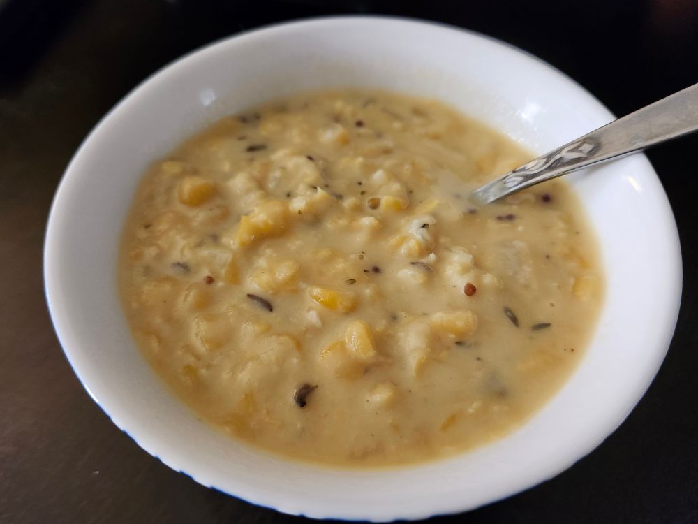 A bowl of yellow split pea soup with caraway seeds