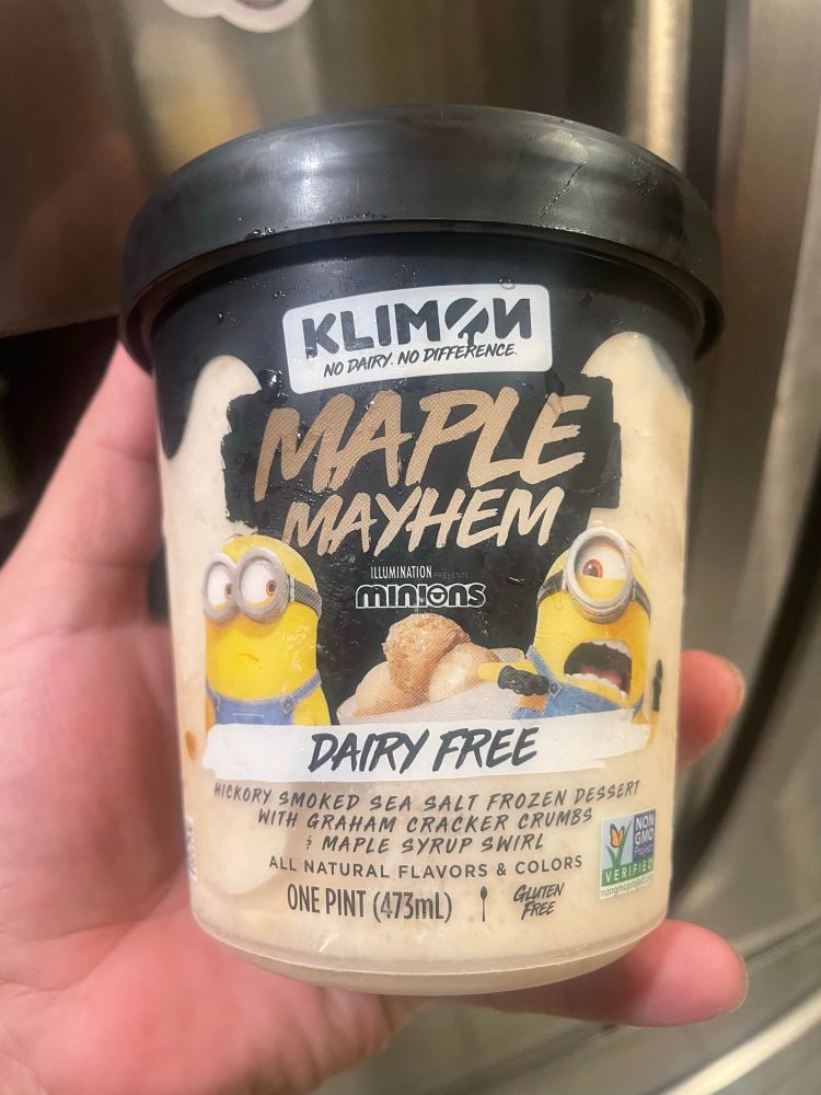 A hand holding a plastic container of a frozen abomination marked by Minions. However, this ice cream did not contain “banana”. It was labeled as follows: 

“MAPLE MAYHEM

DAIRY FREE
HICKORY SMOKED SEA SALT FROZEN DESSERT
WITH GRAHAM CRACKER CRUMBS
+ MAPLE SYRUP SWIRL”