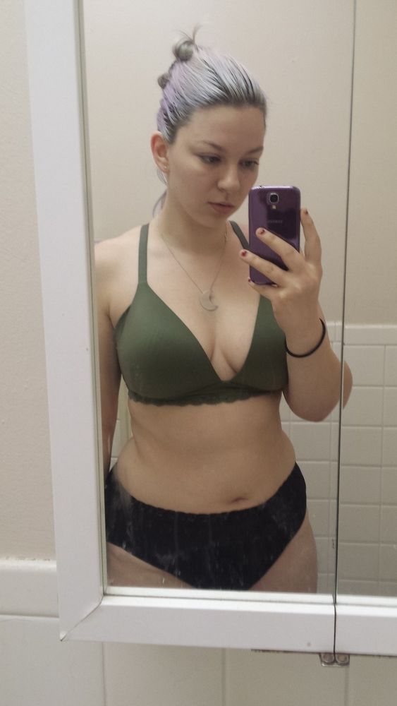 mirror selfie thighs up woman with light purple hair wearing green bra and black high waisted underwear with silver crescent moon necklace 