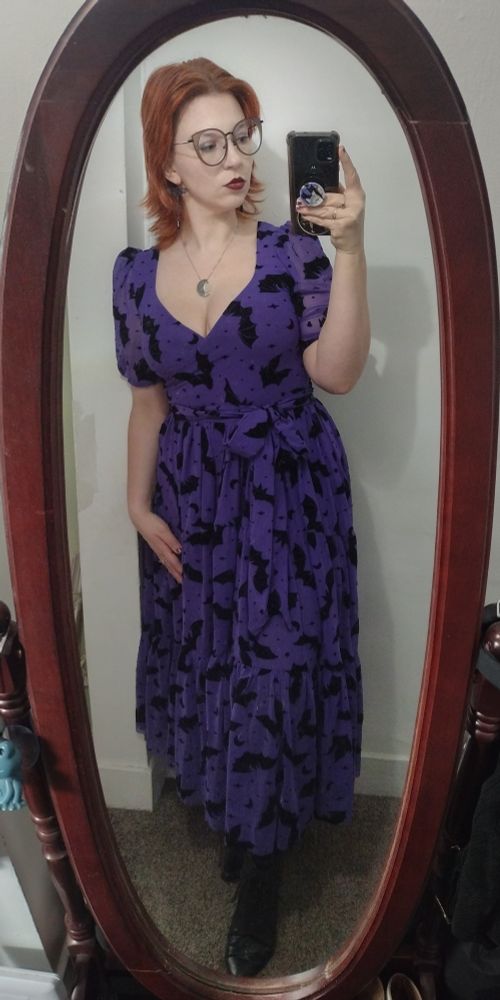 mirror selfie woman red shoulder length hair oversized glasses long purple dress with velvet bats black celestial booties