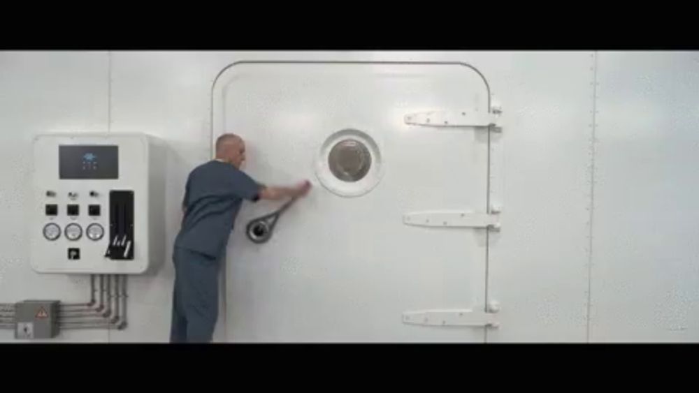 a man in scrubs is opening a door with a small round window