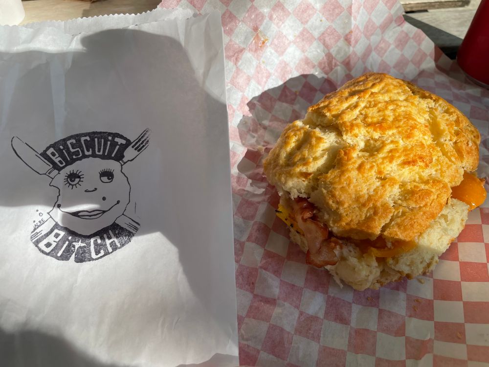 bacon egg and cheese on a biscuit with the biscuit bitch logo on the left