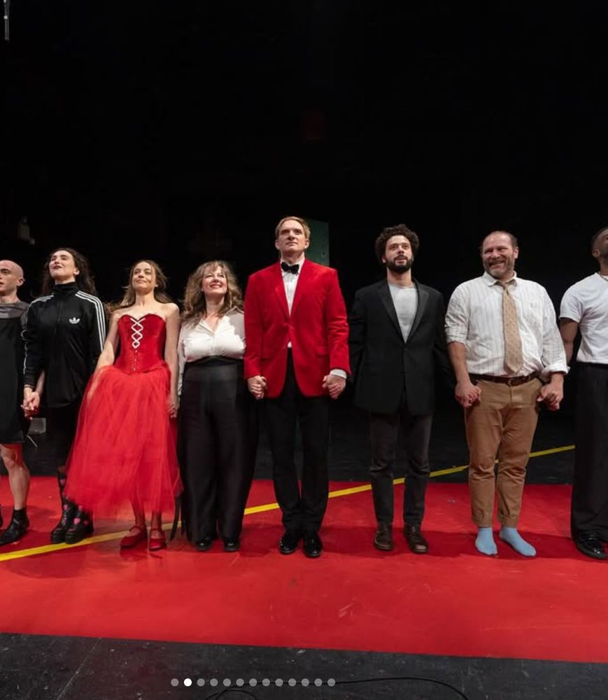 Actors lined up at a curtain call, including, center, Andrey Burkovskiy, a tall man in a black bowtie and red jacket