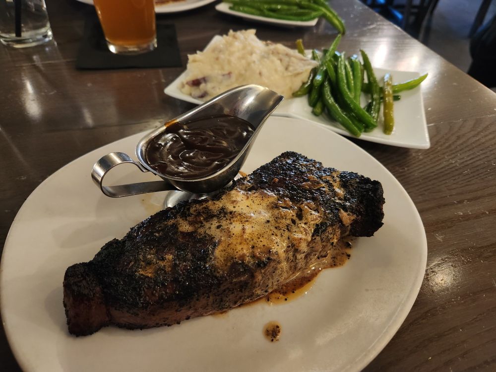 A steak, mashed potatoes and green beans
