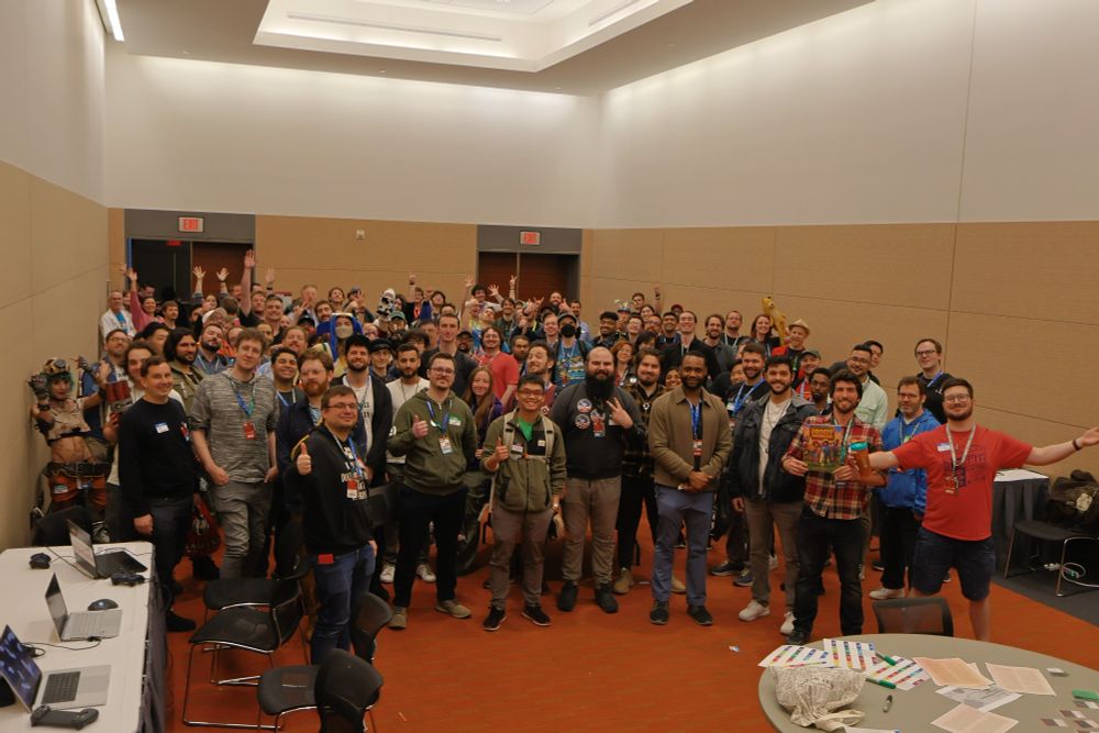 The Gamedev 'n' Chat event. A large crowd of people posing in a conference center room. They look excited!