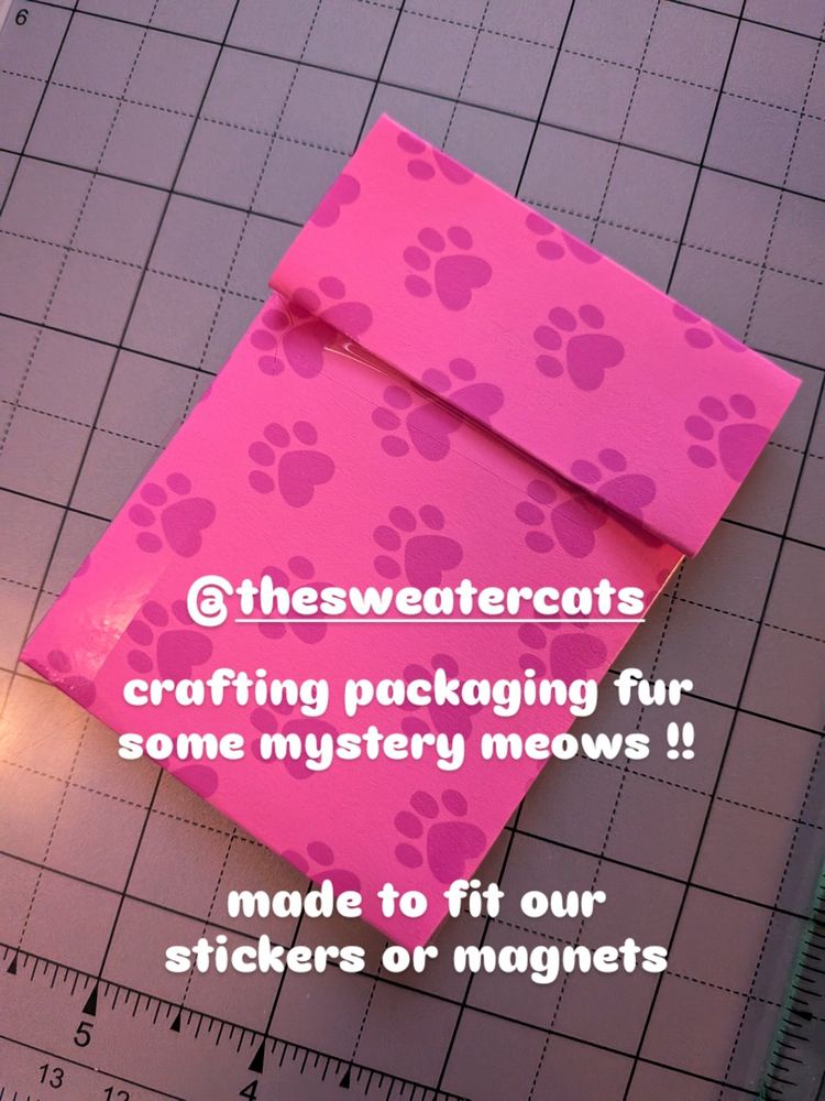 Photo of a closed paper craft envelope we folded. Paw print pattern on it, that we drew as well. 

text
@thesweatercats

Crafting packaging fur some mystery meows!! Made to fit our stickers or magnets.

Keywords
Draw drawing artist art kittens kitten tabby cats meow meows illustration illustration illustrator artists kitties painting painter sketch sketching sketches 