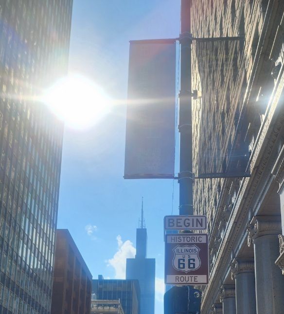 The sign indicating the beginning of Historic Route 66 with the Sears Tower in the background in Chicago, Illinois 