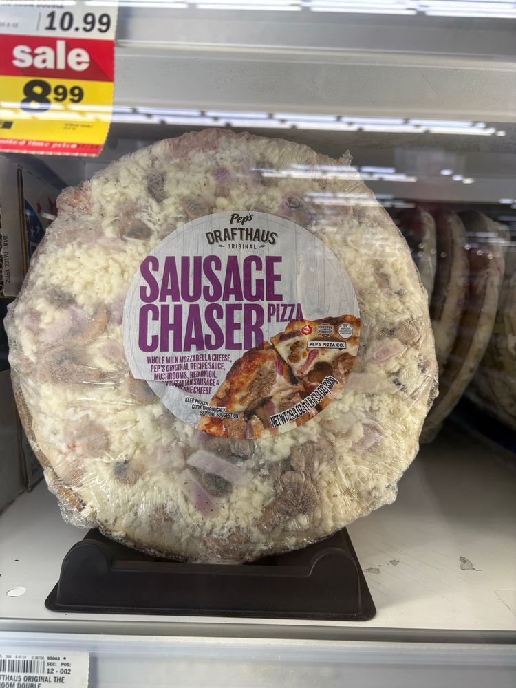 A picture of a frozen pizza at a grocery store that says sausage chaser pizza on the label