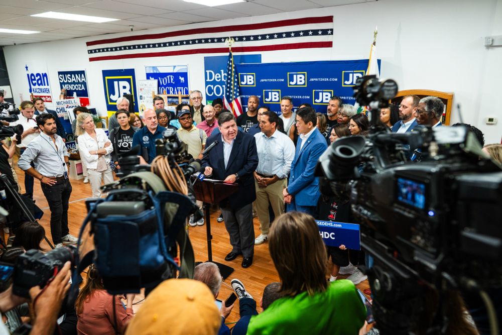 Governor Pritzker speaks while standing next to Texas Democratic legislators.