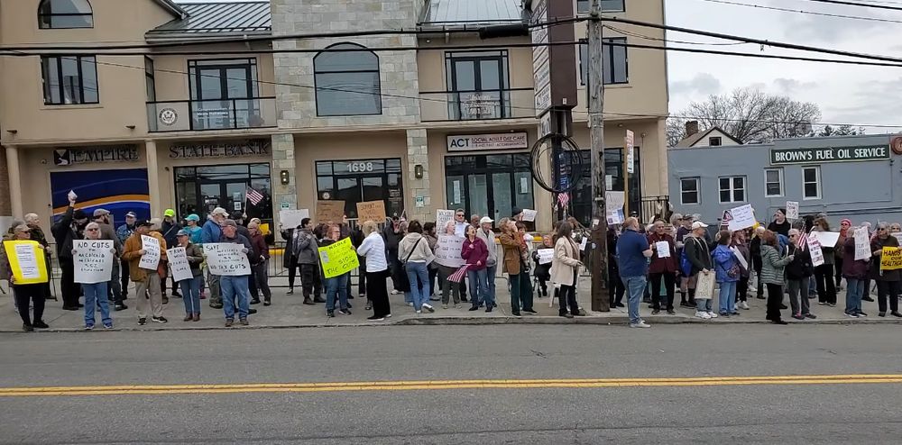 A hundred people rallying with signs outside Malliotakis’ Staten Island office