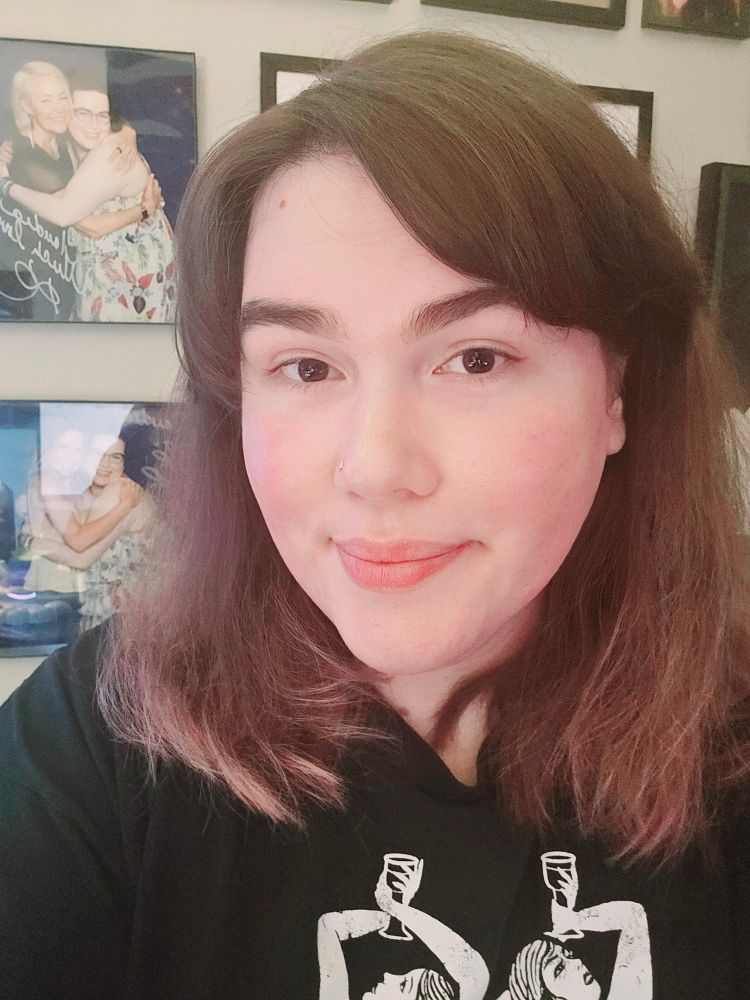 3/4 forward selfie of newly cut hair that sits just below my shoulders, and an attempt was made at bangs. The look on my face is not a confident one.