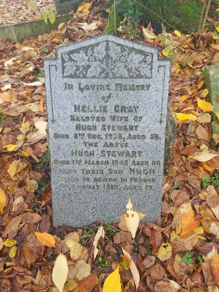 Gravestone of Nellie Gray, wife of Hugh Stewart, surrounded by autumn leaves. Rutherglen Cemetery, South Lanarkshire, Scotland.