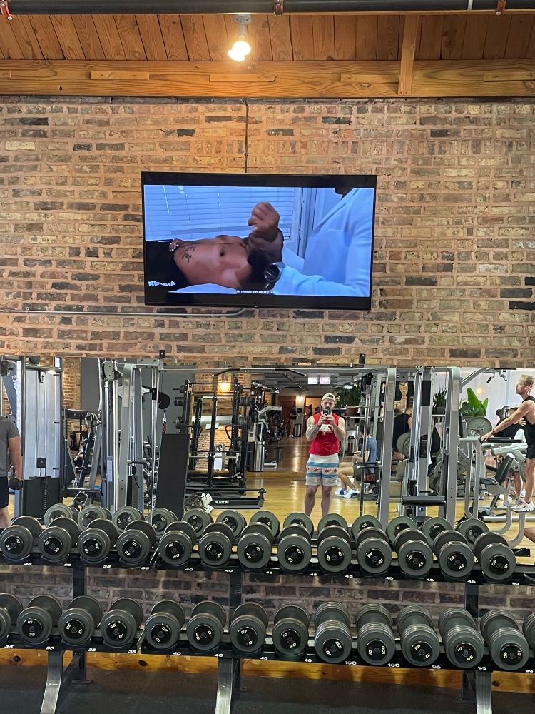 The muscle worship video is still on the tvs above the gym mirrors. You get a bonus terrible pic of me looking like a sweaty wet mess
