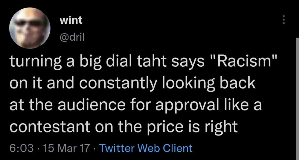 Screen shot of a Dril tweet: turning a big dial taht says “racism” on it and constantly looking back at the audience for approval like a contestant on the price is right 