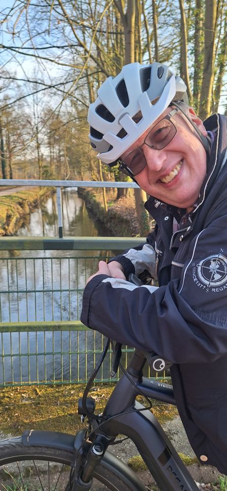 Ralf Sandfuchs mit Fahrradhelm in der freien Natur, im Hintergrund die Anger
